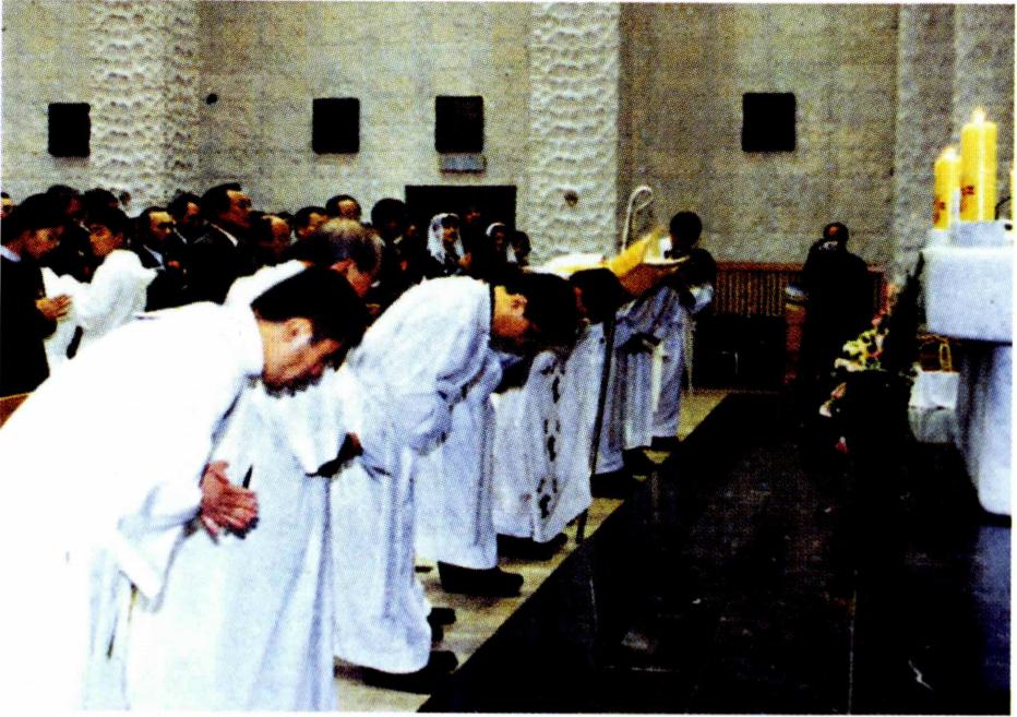 퇴장 직전 제대에 깊은 절을 하는 사제들.